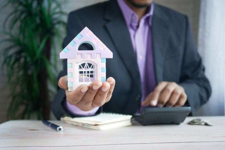 Asesor hipotecario de CreditHome con una casa en miniatura en la mano