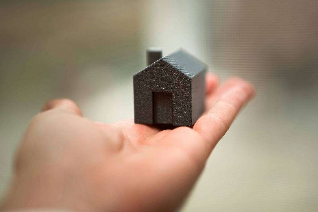 Casa en miniatura sobre la mano